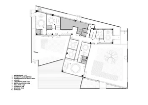 2D floor plan of a modern building with open areas and multiple rooms, featuring linework, labels, and measurements