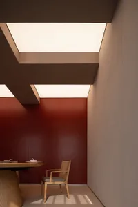 溫馨紅牆餐廳，配木桌與兩把椅子，桌上擺放碗與杯子