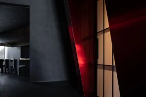 Modern interior design with a bold red accent wall and a black doorway, creating a stylish contrast