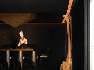 A dining area with a wooden table surrounded by chairs, creating a cozy atmosphere with a modern and functional design