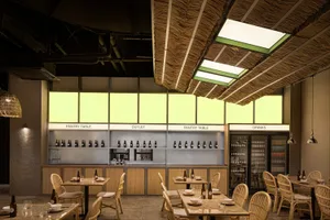 Warm and inviting restaurant interior with wooden tables and chairs, well-lit for a comfortable dining experience