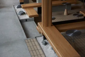 Cozy living space with wooden floors and walls, featuring benches with rocks and a warm atmosphere