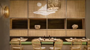 Warm and inviting restaurant interior with wooden walls, tables, chairs, and bowls on the tables