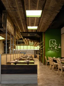 Warm and inviting Asian restaurant interior with wooden tables and chairs, ambient lighting, and a mix of modern and classic design elements