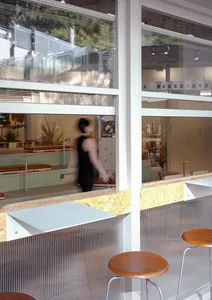 A public space with benches and chairs for seating, surrounded by natural light from a large window
