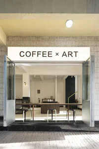 Modern interior design showroom with a coffee shop and art gallery concept, featuring chairs, tables, and a blend of modern and inviting atmosphere