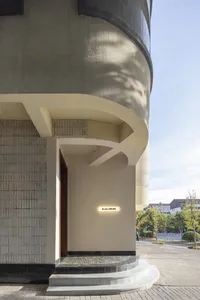 現代建築擁有弧形混凝土牆面與玻璃元素，設有兩扇門並呈現開闊舒適的氛圍