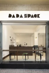 A coffee shop with wooden floors, white walls, and scattered furniture and decor, creating a welcoming atmosphere