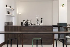 A modern kitchen with wooden cabinets and countertops, featuring a clean and well-organized atmosphere with various items on the counter