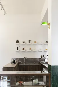 A kitchen with a wooden countertop, metal sink, and various items on the counter, creating a functional and cozy atmosphere for cooking and dining