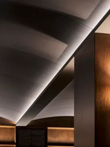 Modern interior space with wooden ceiling and walls, featuring two rooms with warm lighting highlighting the wood