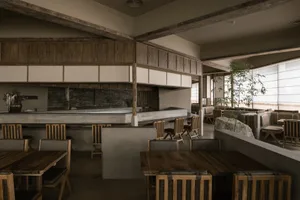 Warm and inviting restaurant interior with wooden tables and chairs, multiple dining areas, and rustic charm