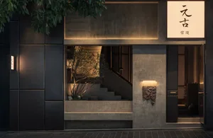 Exterior view of a building with a concrete staircase, two potted plants, and a contemporary urban atmosphere