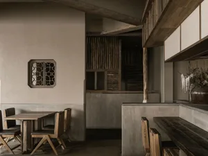 Open modern kitchen and dining space with wooden floors and walls, multiple dining tables, and ample seating options