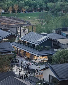 A bustling shopping district at night with multiple buildings, people walking, and vibrant atmosphere