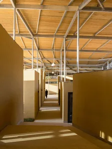 A long hallway with wood accents, two people walking, and a calm atmosphere