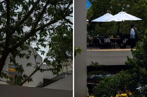 A restaurant or hotel lobby with chairs, a dining table, and umbrellas providing shade and a comfortable atmosphere