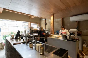Busy commercial kitchen with a refrigerator, countertops, and various objects and appliances