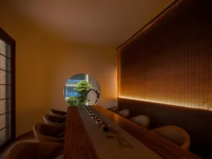 Warm and inviting restaurant interior with wooden tables and chairs, multiple dining tables, and a cozy atmosphere