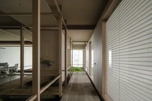 Warm and inviting living space with wooden walls and floor, potted plants, and decorative vases