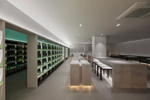 Modern restaurant interior with white walls, wooden furniture, and lamps providing warm lighting