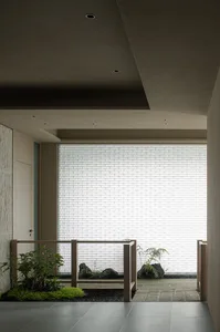 A bright and inviting indoor space with potted plants, vases, and a large window allowing sunlight to enter
