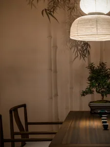 A cozy dining space with a wooden table and chairs, a potted plant, and a warm atmosphere