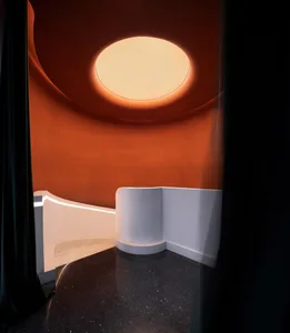 A bright and inviting modern room with a circular shape and a large glass window allowing natural light to enter