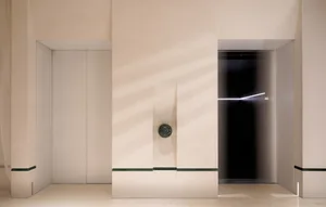 Classic hallway with a stone clock on the wall, a doorway leading to another room, and a timeless design