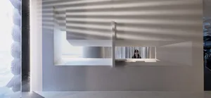 Office space with a receptionist's desk made of concrete, two chairs, and natural light from a window