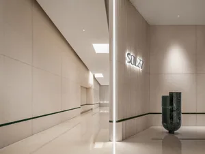 A calm and inviting hotel hallway with white marble flooring, two large vases, and a focus on aesthetics