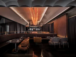 A modern restaurant with multiple tables and chairs, creating an inviting and comfortable atmosphere for guests