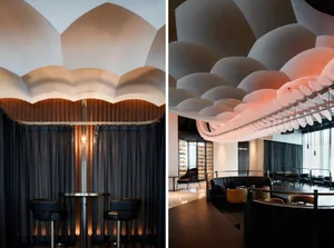 Modern restaurant interior with a dining area, bar, and tables, featuring bottles and a stylish atmosphere
