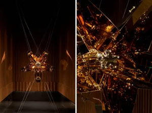 A modern lobby with office chairs and a large glass sculpture hanging from the ceiling, creating a unique and well-designed space