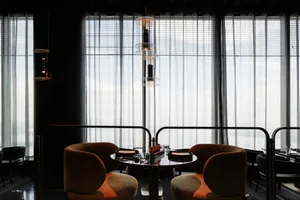 A formal dining area with two round tables and four chairs, featuring place settings and decorative accents, set in a well-lit space