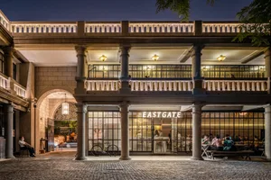 A cozy cafe with a large archway, people enjoying the atmosphere, and bicycles parked outside