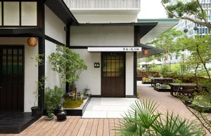 Asian-style house with a wooden deck, potted plants, and umbrellas, creating a calm and inviting atmosphere