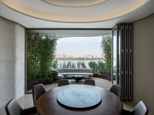 A cozy dining area with a wooden table surrounded by chairs, potted plants, and a bench, creating a warm and inviting atmosphere for meals and gatherings