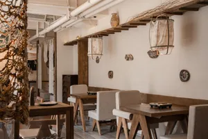 Warm and inviting restaurant interior with wooden tables and chairs, multiple dining tables and seating options