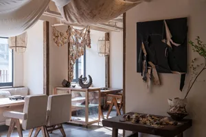 Cozy modern living space with a dining table, couches, chairs, vases, and books