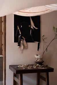 A gallery space with various artworks on the wall, showcasing creative pieces in different sizes and positions