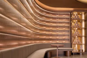 A warm and inviting restaurant interior with a brown-painted curved wall, two couches, and a dining table