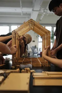 一群人在辦公環境中共同工作，周圍環繞植物、椅子，以及餐桌上各種物品