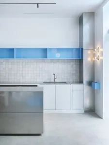 Modern kitchen with stainless steel countertops, metal cabinets, and overhead lighting