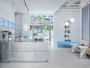 Open kitchen with a large window, countertop, sink, appliances, dining table, chairs, and couches, creating a clean and well-organized space for cooking and socializing