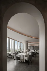 Spacious restaurant dining area with multiple tables and chairs, modern design with clean lines and minimal decoration