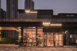 Modern Asian restaurant with a sleek glass exterior, dining tables, chairs, and umbrellas inside