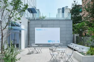 A patio area with chairs and dining tables on a tiled floor, creating a comfortable outdoor space for dining and gatherings