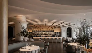 現代餐廳內部，設有酒吧、餐桌與舒適座椅，白色與米色牆面營造優雅氛圍