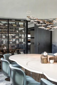 Sophisticated dining space with a large wooden table, wine bottles, and comfortable seating